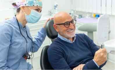 mature man looking at mirror and smiling - Church Street Dental Care Toronto